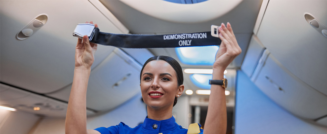 Azafata realizando demostración de seguridad en cabina