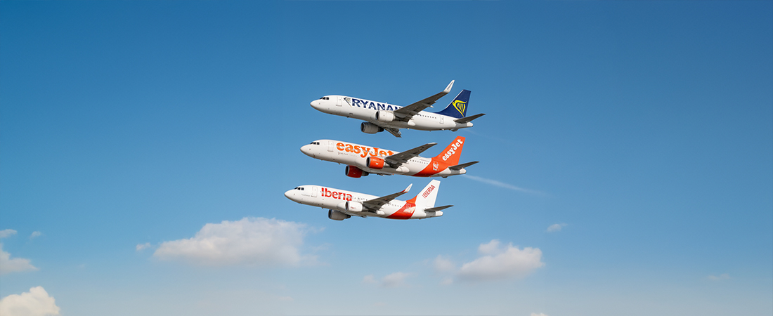 Cuatro aviones de pasajeros volando en formación en un cielo azul despejado.
